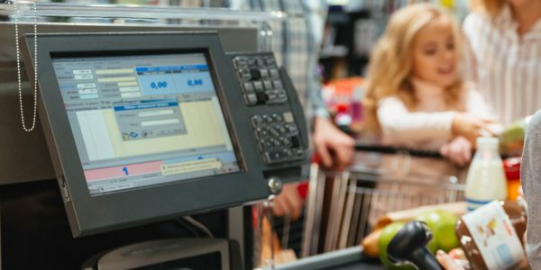 Beautiful family standing at the cash counter buying groceries at the supermarket